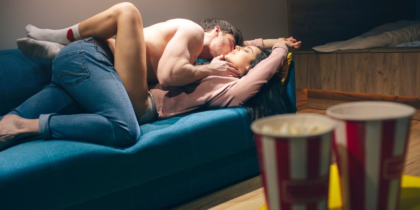 Pareja besándose durante una noche de películas eróticas en casa | lovesexshop.es sex shop